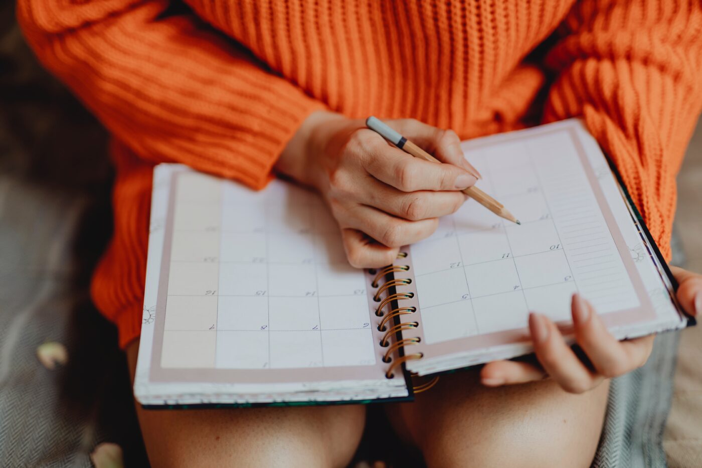 girl in orange sweater with calendar book