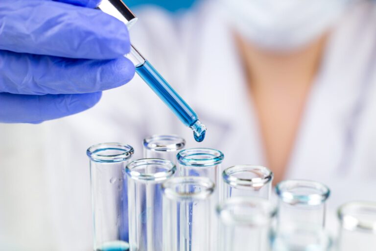 Lab technician dropping water droplets into test tubes