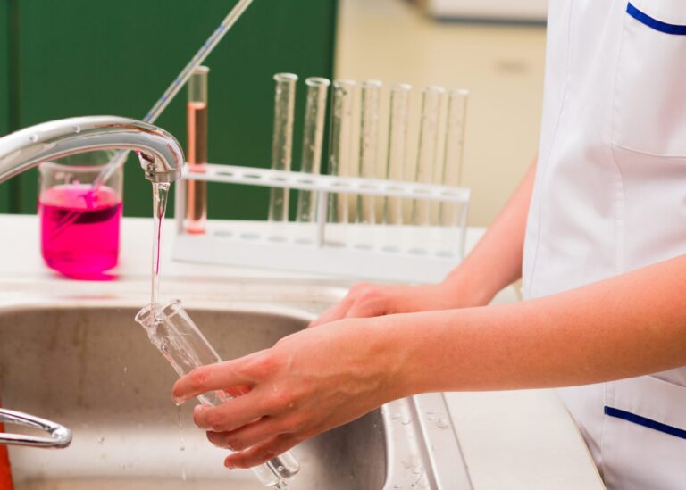 Lab technician filling a test tube with water from the sink