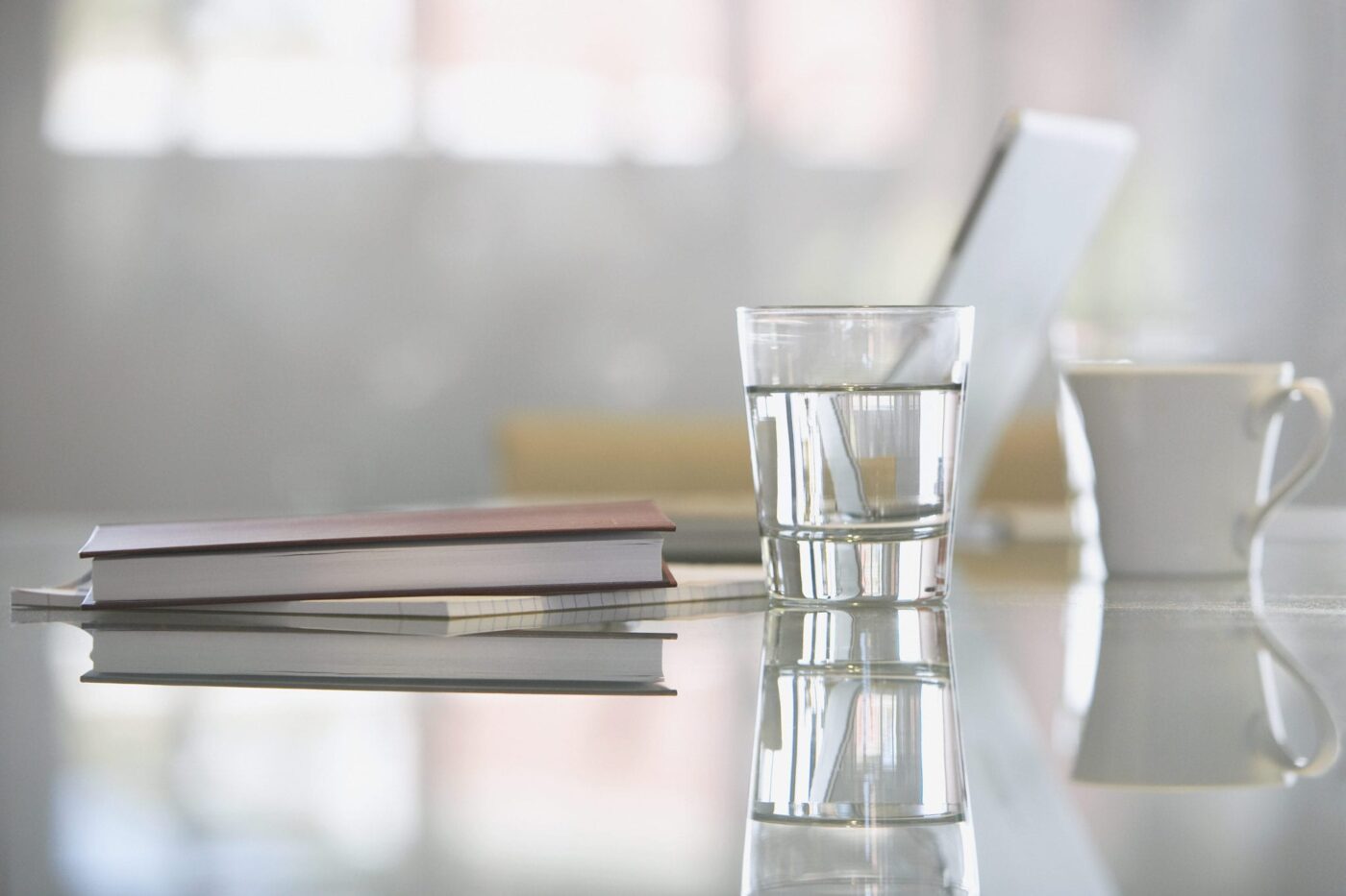 Close-up of glass with water on desk with laptop