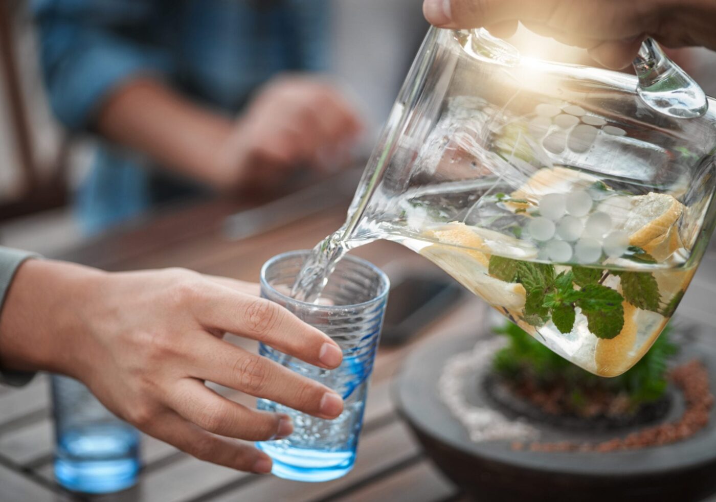 Pouring lemon water from a pitcher into a glass