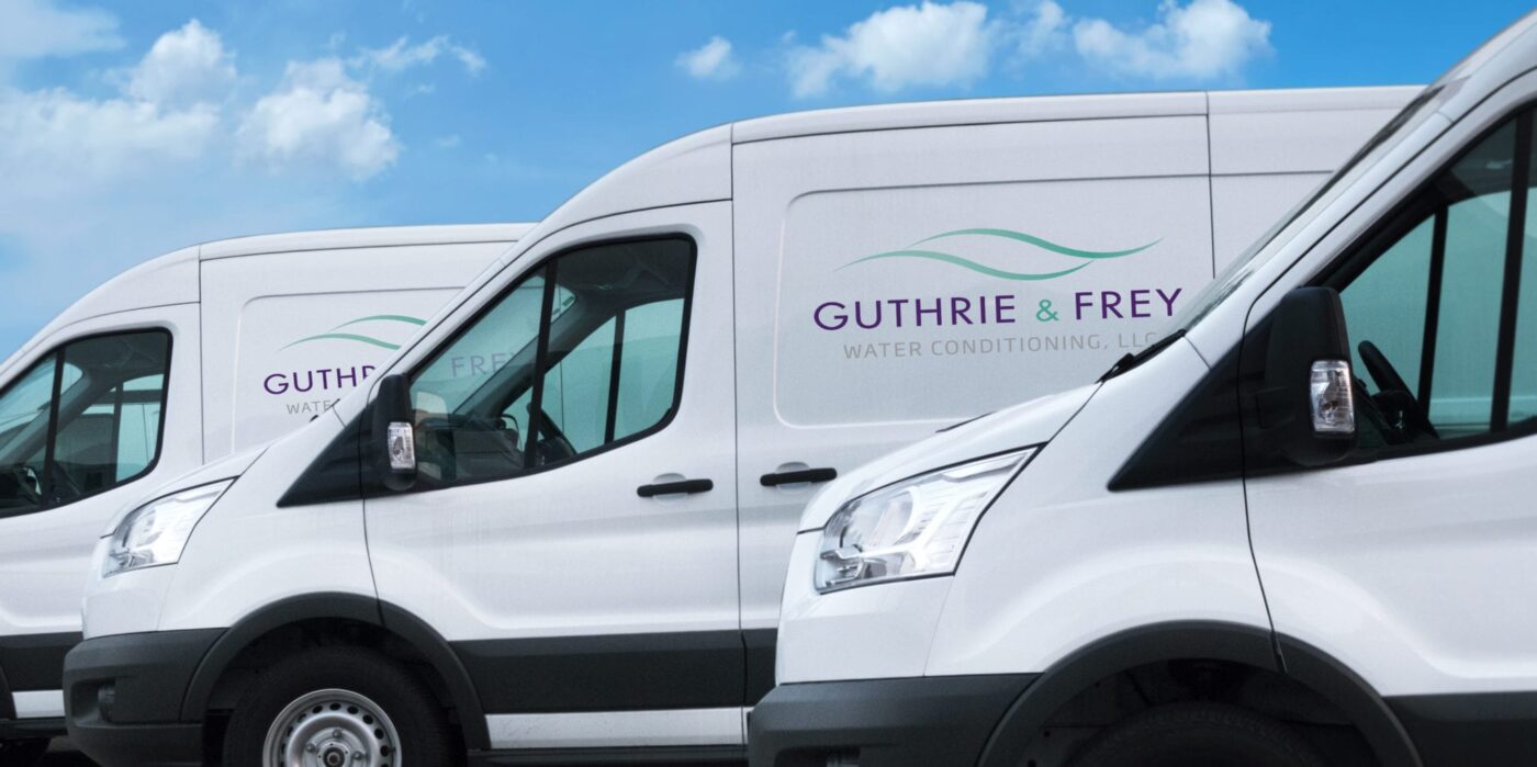 3 white delivery trucks in a line outside